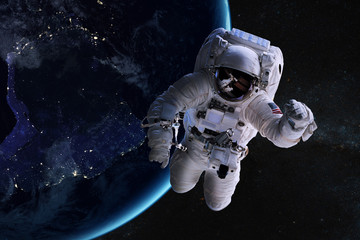 Fototapeta na wymiar Astronaut in outer space on background of the night Earth. Elements of this image furnished by NASA.