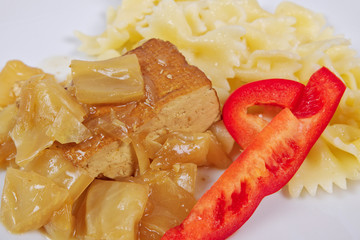 Tofu with vegetables and pasta on a white