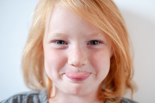 Girl with freckles showing tongue closeup