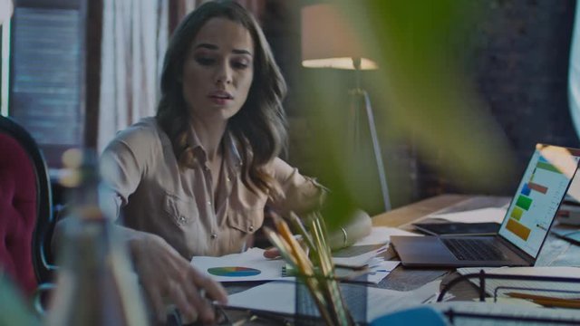 Concentrated businesswoman making notes on paper. Hurry specialist answering call. Angry business woman talking phone. Annoyed woman working in office. Female employee interrupted at work