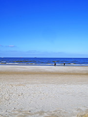 Fototapeta na wymiar Spacerujące osoby na plaży