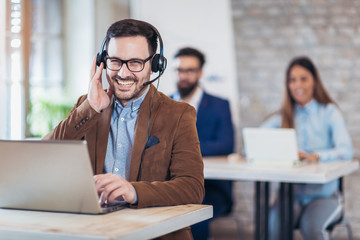 Portrait of happy smiling customer support phone operator at workplace.