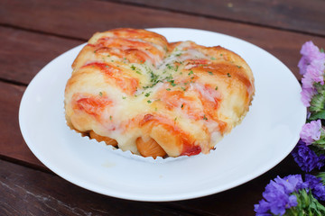 Sausage mayonnaise bun in white dish on wooden table