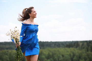 Young cute girl run in a field at sunset