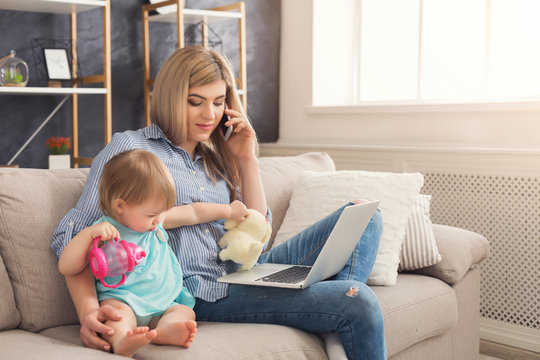 Young mother working and spending time with baby