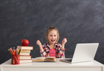 Beautiful female child playing online game on laptop