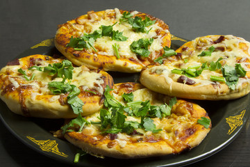 Small pizzas on a black plate