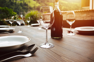 Weinflasche und Weingläser auf dem Tisch während des Sonnenuntergangs