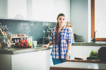 Happy woman drinking tea in the kitchen at home.
