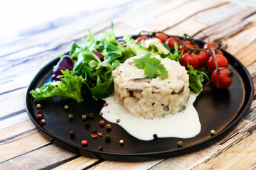 Tasty risotto with Shrimp, fresh herbs vegetables on a white plate