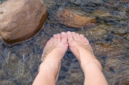 Female feet in water, refreshing in the river. - Powered by Adobe