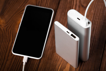 battery bank for charging mobile devices. Silver smart phone charger with power bank. External battery for mobile devices.