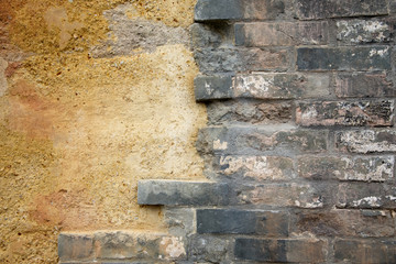 Layered wall erosion with bricks. Texture of an old brick wall.