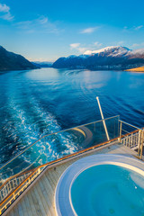 Obraz premium Above outdoor view of Hurtigruten voyage in cruise along Norwegian coast with a luxury swimming pool with a gorgeous nature background