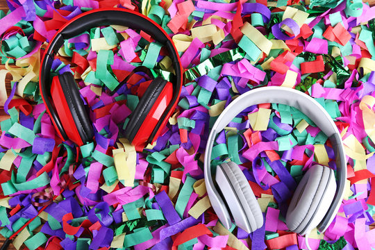 Red and white headphones on colourful confetti