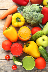 Vegetables smoothie in glasses on grey wooden table