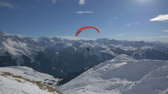 Paraglider flying above mountains