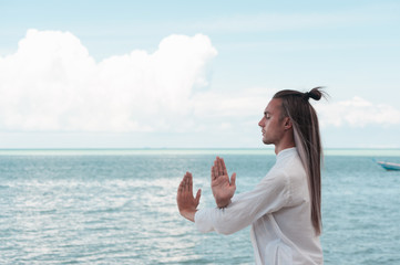 Handsome man is practicing Taijiquan on the beach
