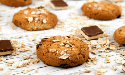 Obraz na płótnie Canvas Homemade cookies and chocolate pieces on a white vintage table.