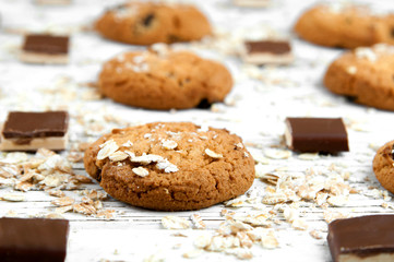 Homemade cookies and chocolate pieces on a white vintage table.