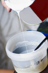 Mixing paints in a plastic container. Tinting paint.