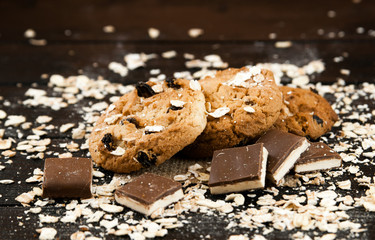Homemade cookies and chocolate on a black table.