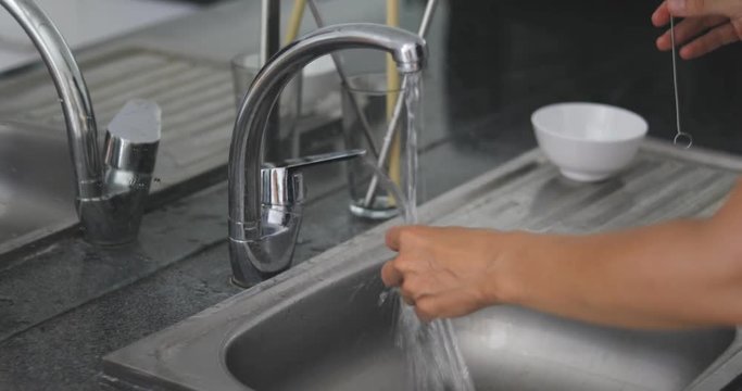 4k footage of woman standing on kitchen and washing reusable glass straw. Zero waste concept 4k