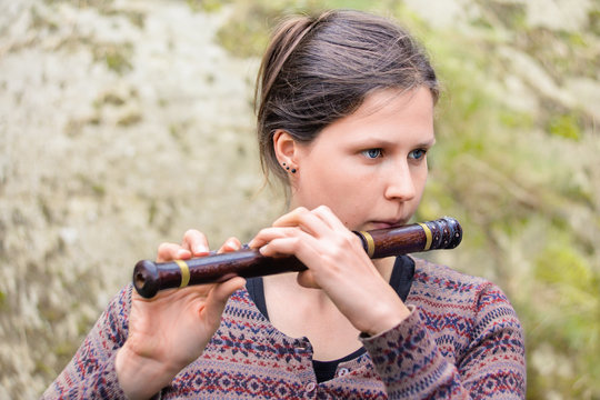 Woman playing an indian wooden flute