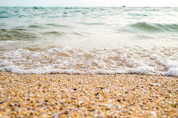 Tropical beach with wave,blue sky on golden beach sand in sunset light