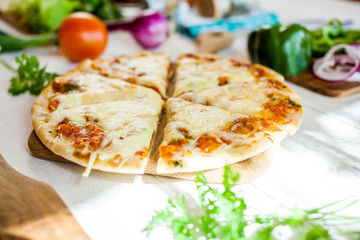 closeup fresh homemade traditional cheese italian pizza on wooden table with ingredients around. wallpaper for pizzeria and cooking food concept