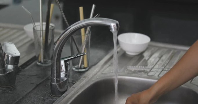 4k footage of woman standing on kitchen and washing reusable bamboo straw. Zero waste concept