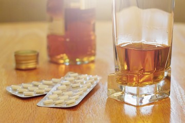 Pills and alcohol on the table, dependency concept