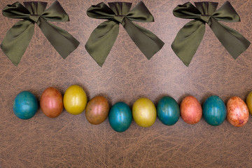 Painted easter eggs with bows uniform background .