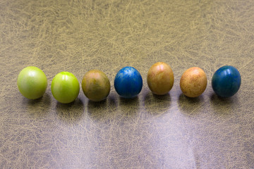 Colorful pastel easter eggs on wooden board background with space. Vintage toned.