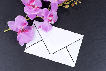 Blank mourning card with orchids as decoration on black background