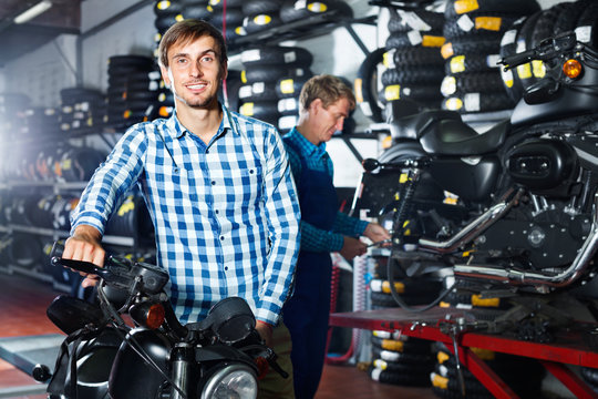 Portrait of customer choosing new motorbike in workshop