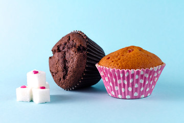 Muffins and sugar pieces lie on a blue background.