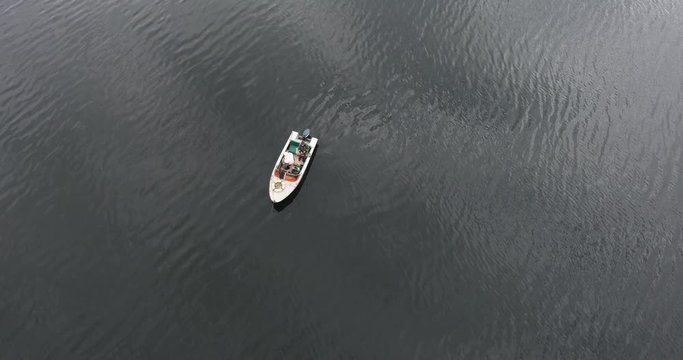 Top view of a boat with a fisherman who catches fish for fishing rod