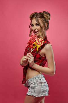 Cheerful young woman with lollipop.