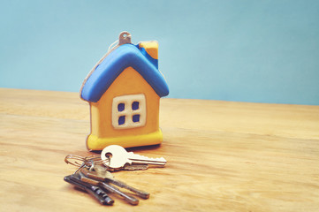 keys with house shaped key ring on a wooden table