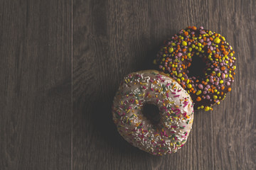 Two donuts lying on the table and on a black background. Space for text.