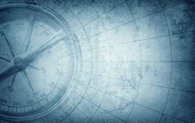 Old vintage retro compass on ancient map. Survival, exploration and nautical theme grunge blue...