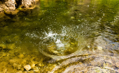 Circles on the surface of water with stones on the bottom