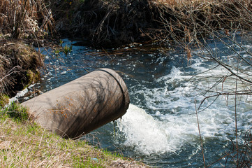 Concrete pipe transporting the poluted river in to a small pound.