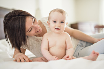 mother playing with her baby in the bedroom