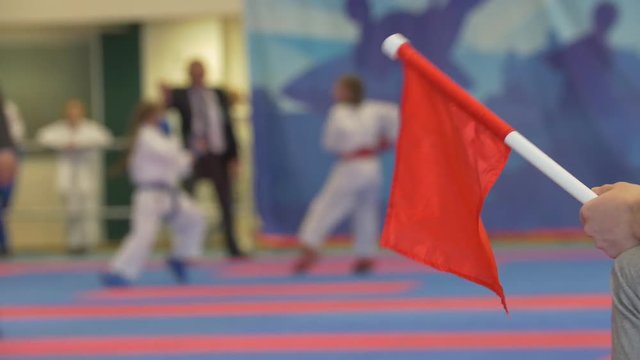 Red flag in front of teenager girls fighting at the karate tournament