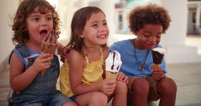 Happy multi-ethnic children eating ice-cream on summer holidays