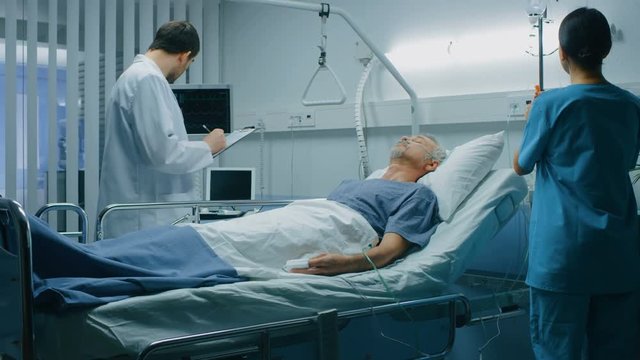 In the Hospital Sick Man Rests, Lying on the Bed, Doctor and Nurse Enter Ward and Check up the Patient. Shot on RED EPIC-W 8K Helium Cinema Camera.