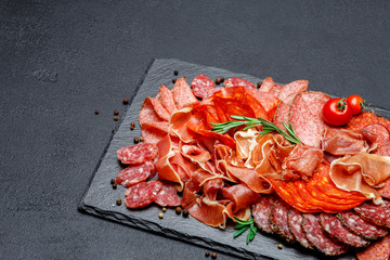 Various types of Dried organic salami sausage and parma on concrete background