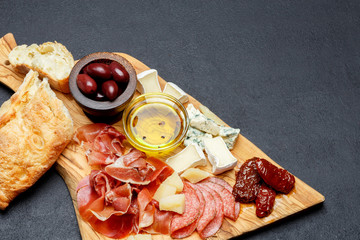 Meat and cheese plate with salami sausage, chorizo, parma and brie cheese